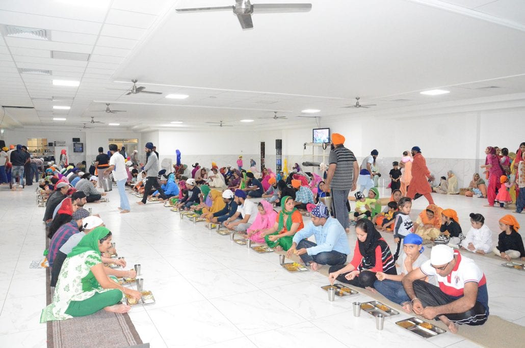 Sangat seated together in pangat in the langar hall